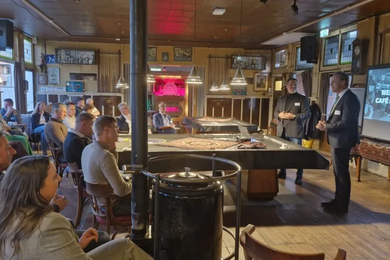 Deelnemers luisteren naar twee sprekers tijdens de Familiebedrijven Meet-up in Café Baarends.