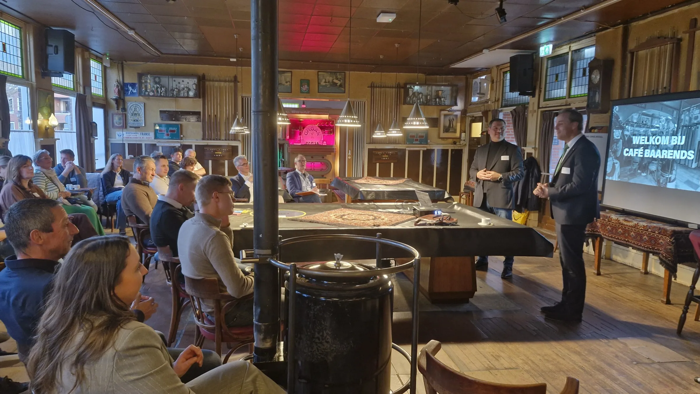 Deelnemers luisteren naar twee sprekers tijdens de Familiebedrijven Meet-up in Café Baarends.